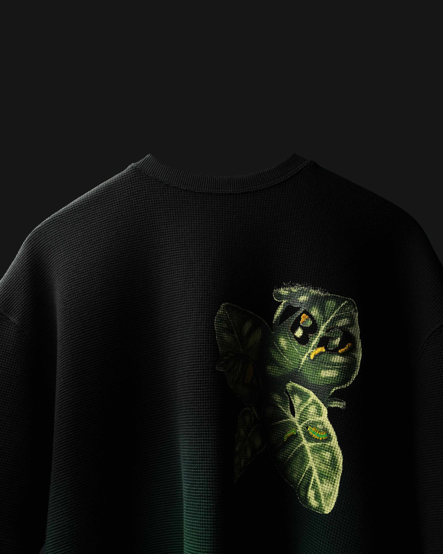 Black Fade Flora with green caterpillar design on a dark background