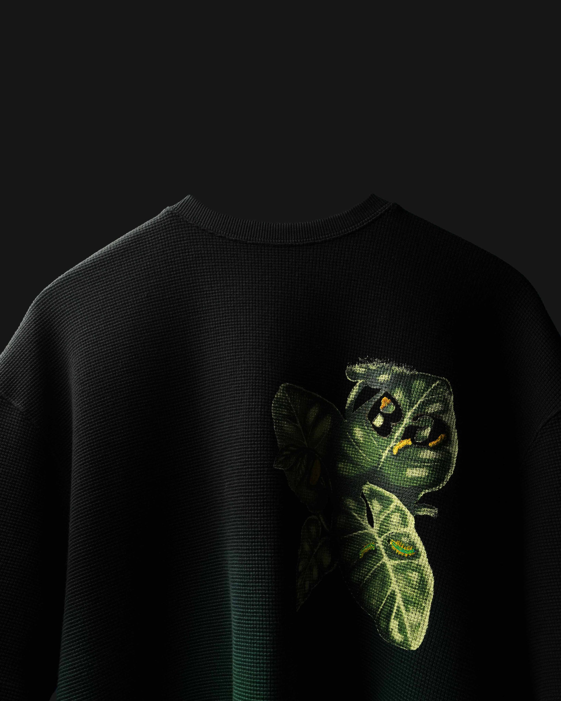 Black Fade Flora with green caterpillar design on a dark background