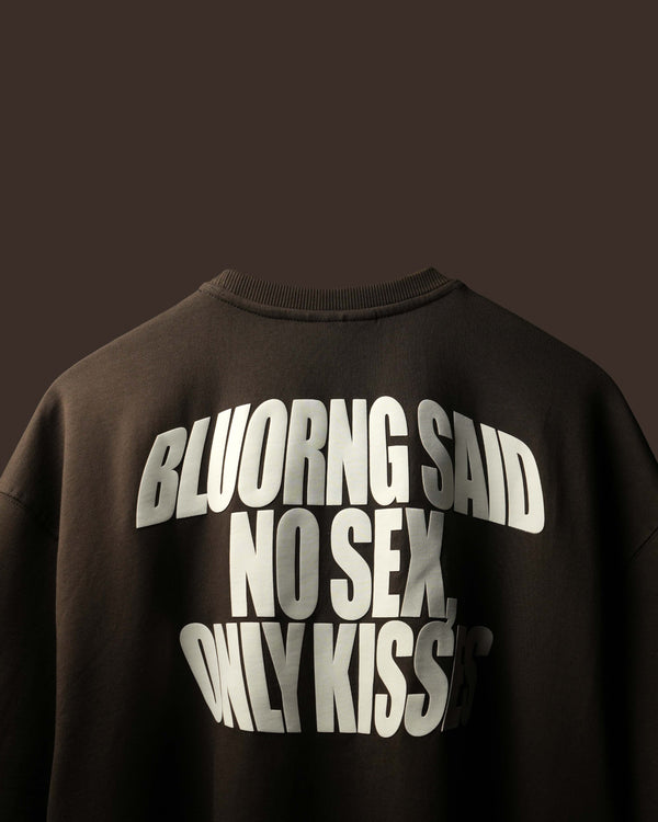A close-up of the back of a black crewneck sweatshirt featuring large, arched white text that reads 'BLUORNG SAID NO SEX, ONLY KISSES'.