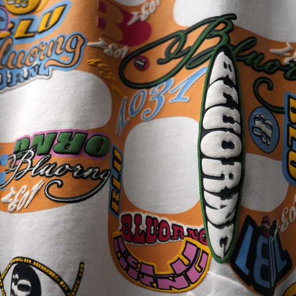 White oversized premium tee featuring bold sticker slap graphics